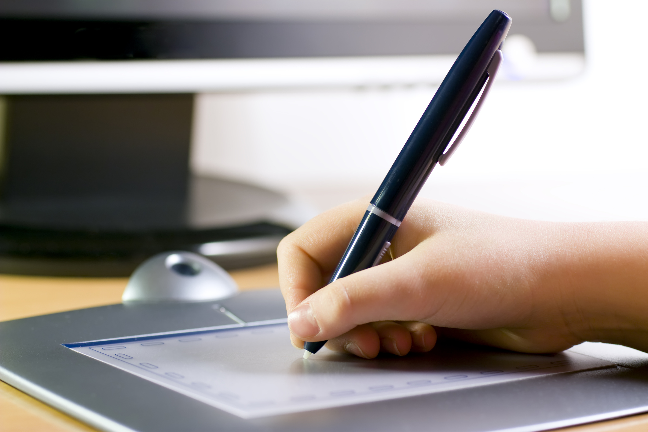 Drawing on graphic tablet Hand holding pen on wireless tablet